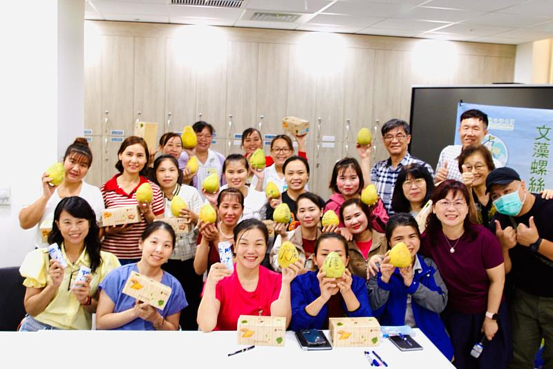 師生與越南籍移工合影，手持柚子