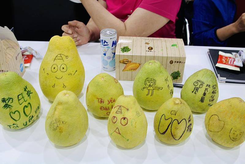 移工在柚子上創作彩繪